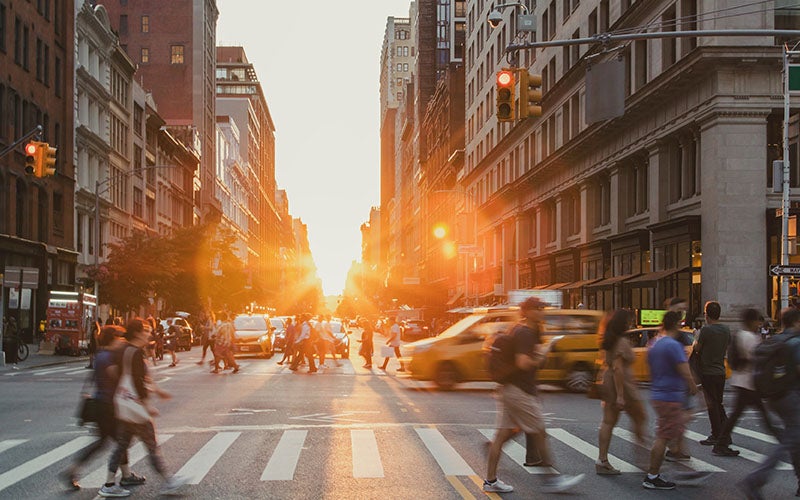 Busy New York City street with yellow taxis and pedestrians crossing at an intersection