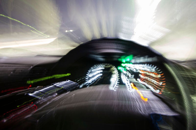 Abstract shot of a car dashboard at night with extreme motion blur and light streaks, conveying speed.